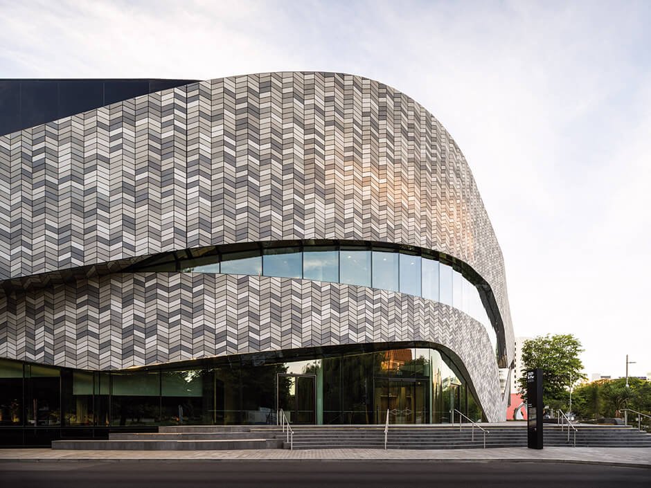 Tiled facade wraps curved convention centre by Woods Bagot and Warren & Mahoney