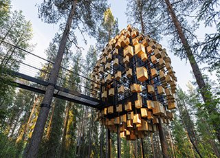 BIG wraps Lapland hotel treehouse in 350 birdhouses